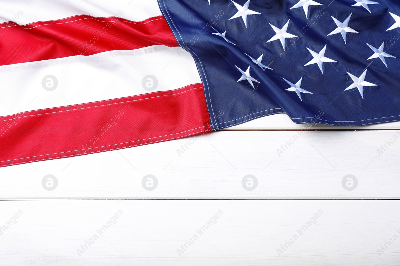 Photo of National flag of America and space for text on white wooden table, top view