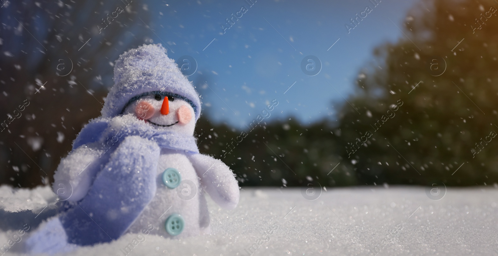 Photo of Cute small decorative snowman outdoors on winter day, space for text