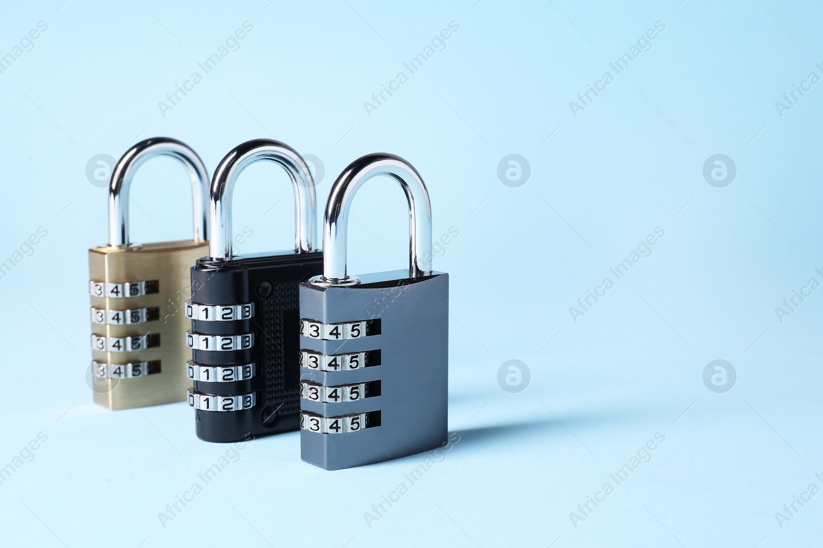 Photo of Steel combination padlocks on light blue background. Space for text