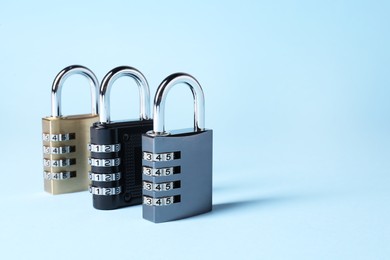 Photo of Steel combination padlocks on light blue background. Space for text