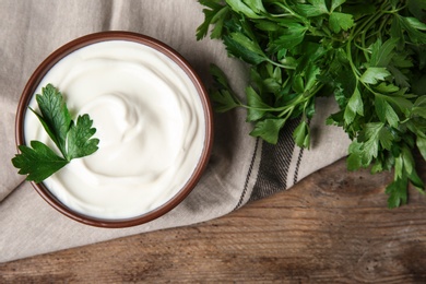 Photo of Flat lay composition with sour cream and parsley on wooden table