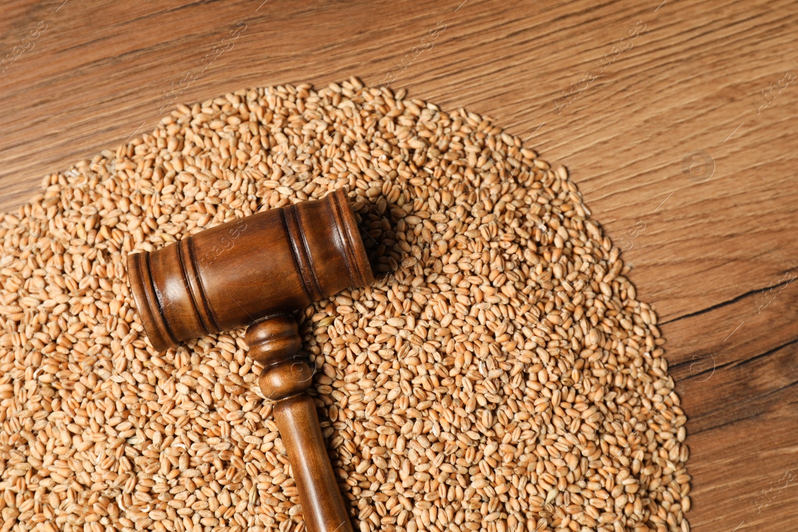 Photo of Agricultural deal. Judge's gavel and wheat grains on wooden table, top view. Space for text