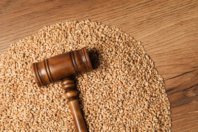 Agricultural deal. Judge's gavel and wheat grains on wooden table, top view. Space for text