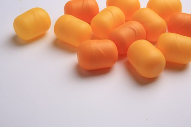 Photo of Sveti Vlas, Bulgaria - June 30, , 2023: Orange plastic capsules from Kinder Surprise Eggs on white background, closeup and space for text