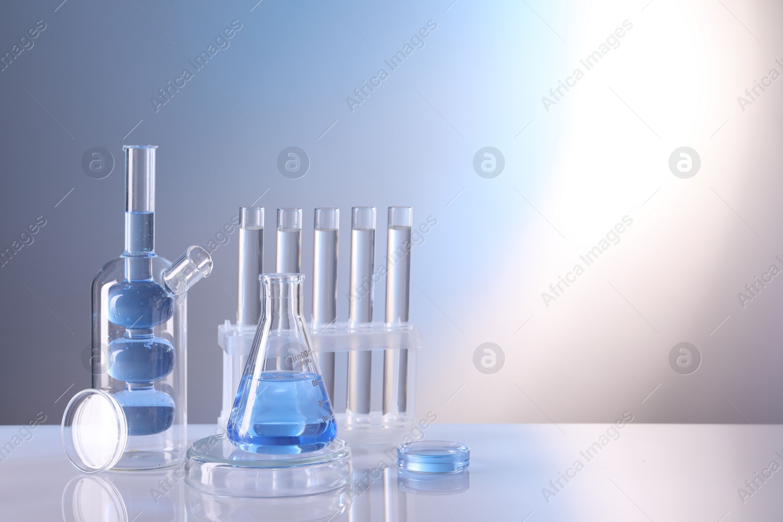 Photo of Laboratory analysis. Different glassware on table against light background, space for text