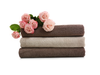 Photo of Stack of clean folded towels with flowers on white background