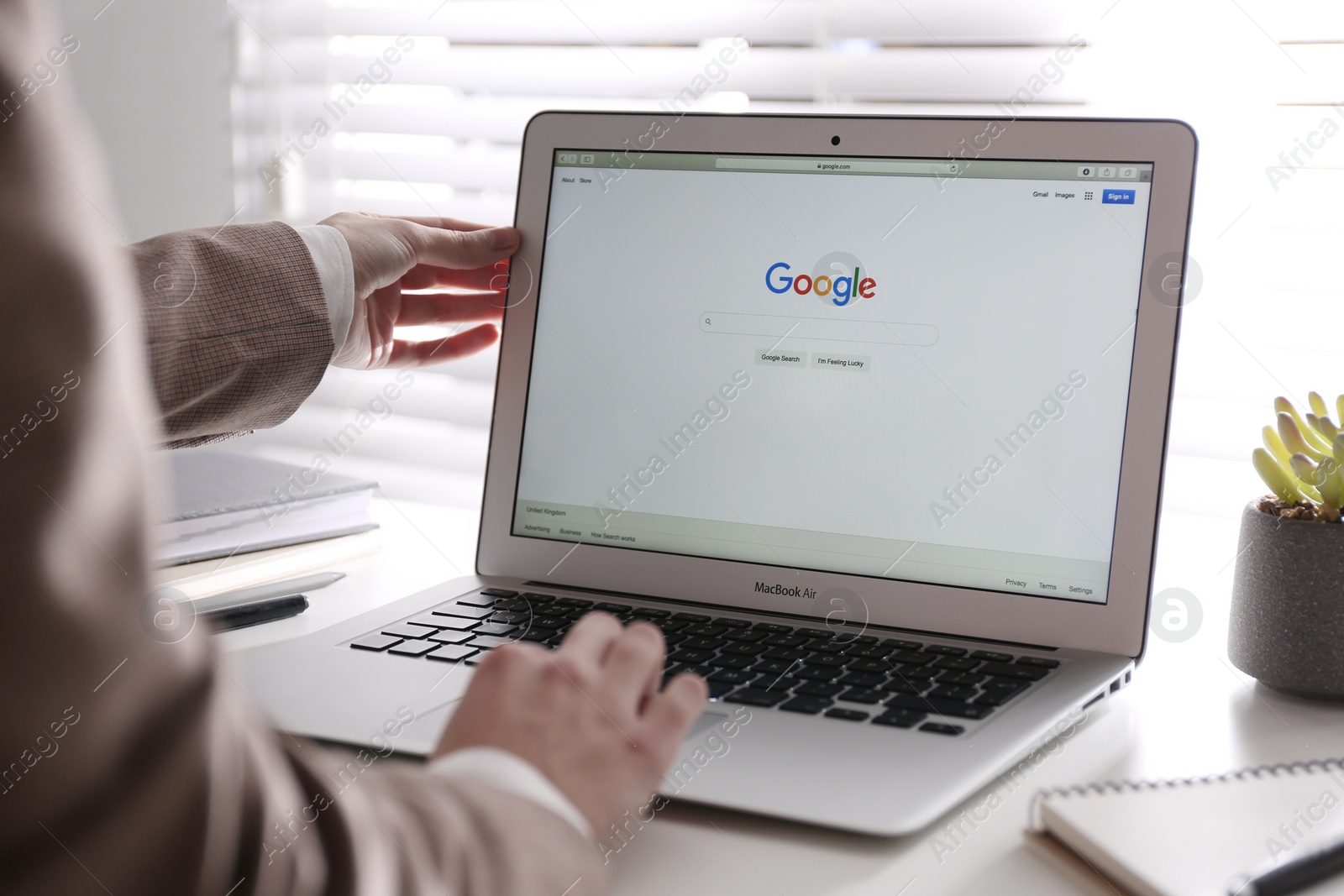 Photo of MYKOLAIV, UKRAINE - NOVEMBER 13, 2020: Woman using Google search on Apple Macbook Air in office, closeup