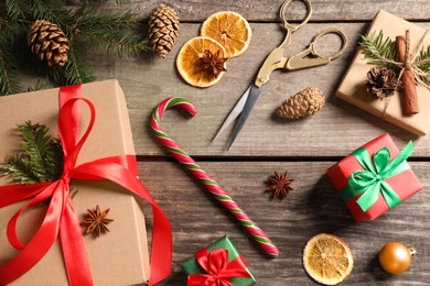 Photo of Flat lay composition with beautiful gift boxes and Christmas decorations on wooden table