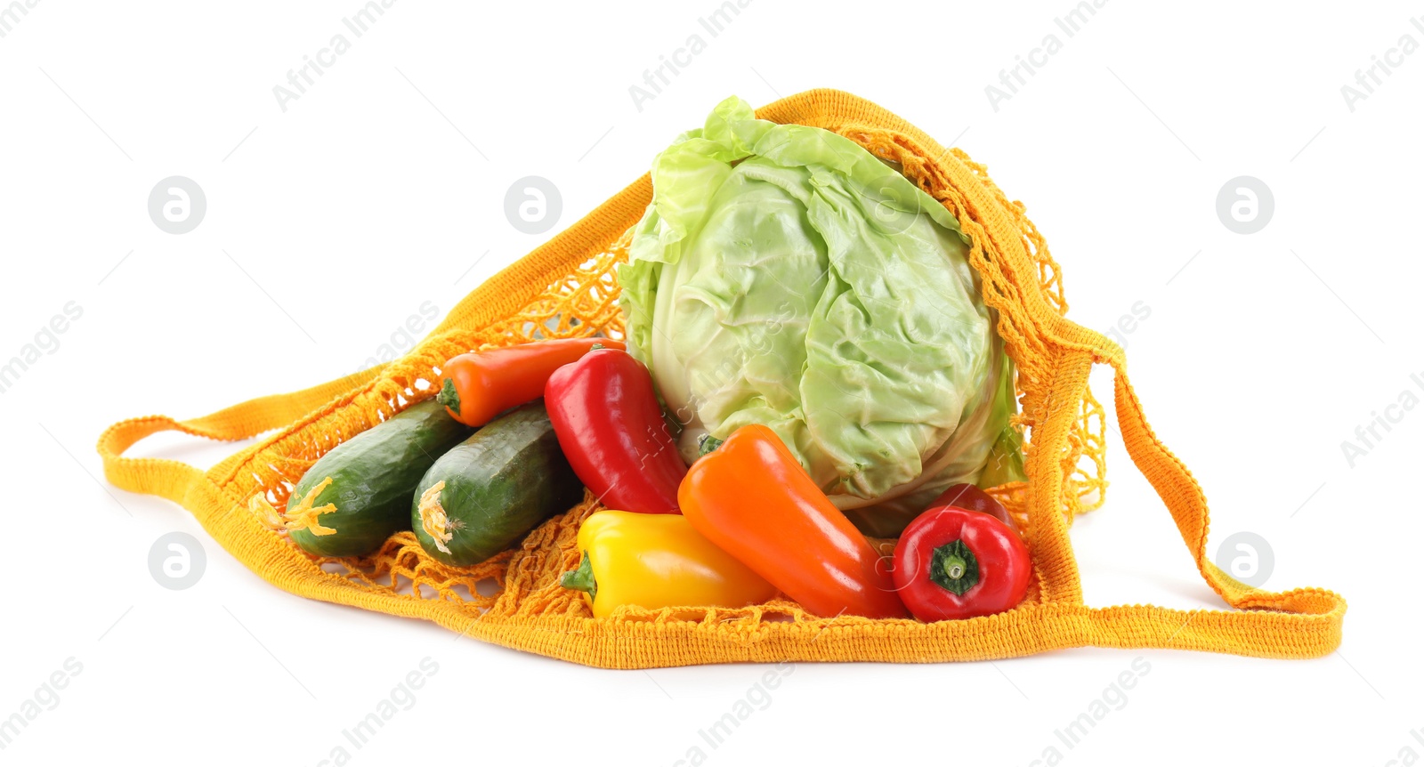 Photo of String bag with different vegetables isolated on white