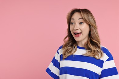 Photo of Portrait of happy surprised woman on pink background. Space for text