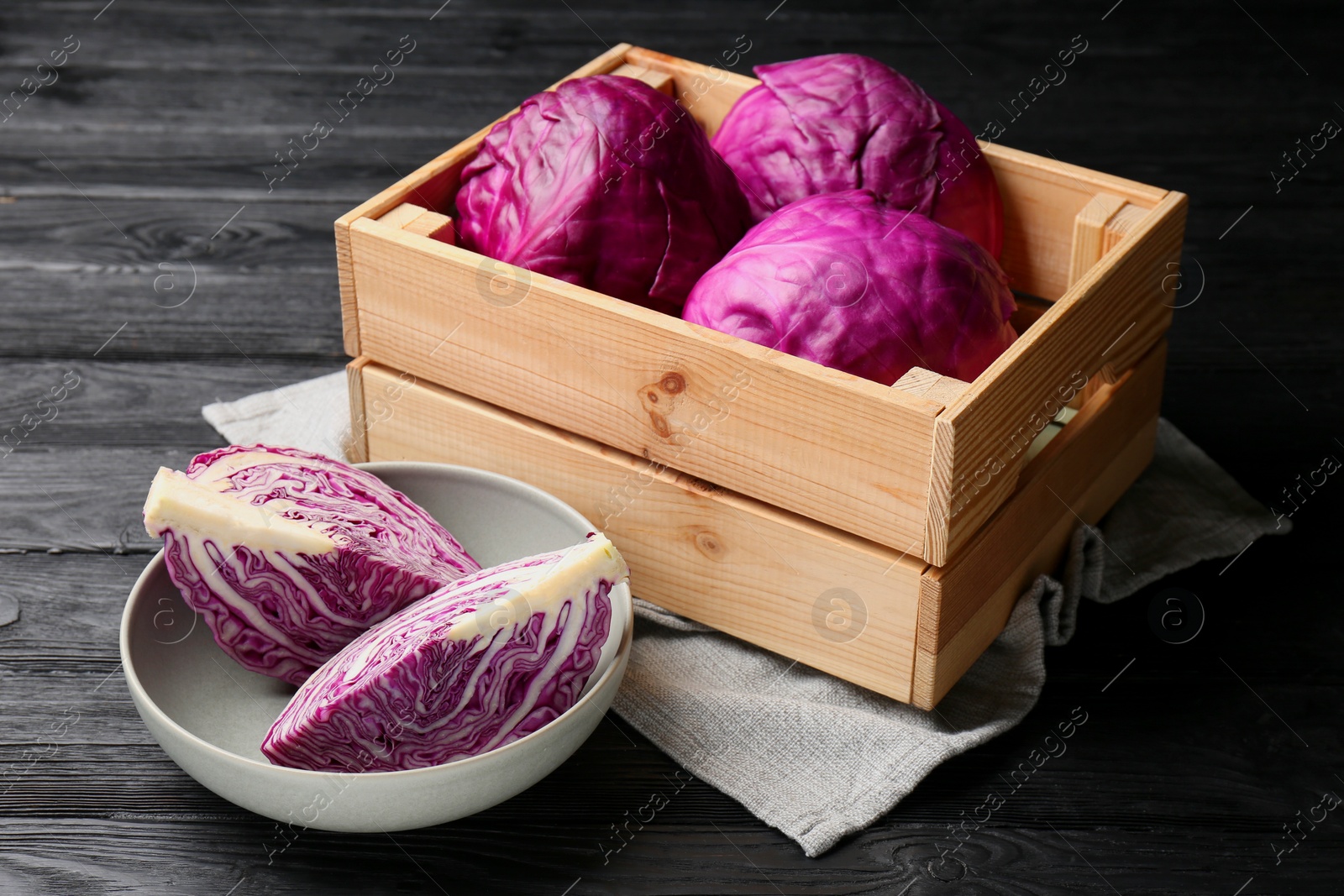 Photo of Fresh red cabbages on black wooden table