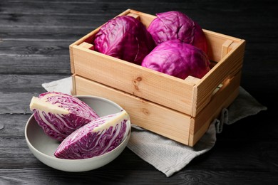 Photo of Fresh red cabbages on black wooden table