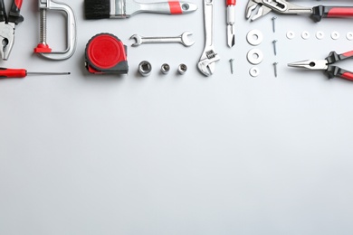 Photo of Flat lay composition with construction tools on light background, space for text