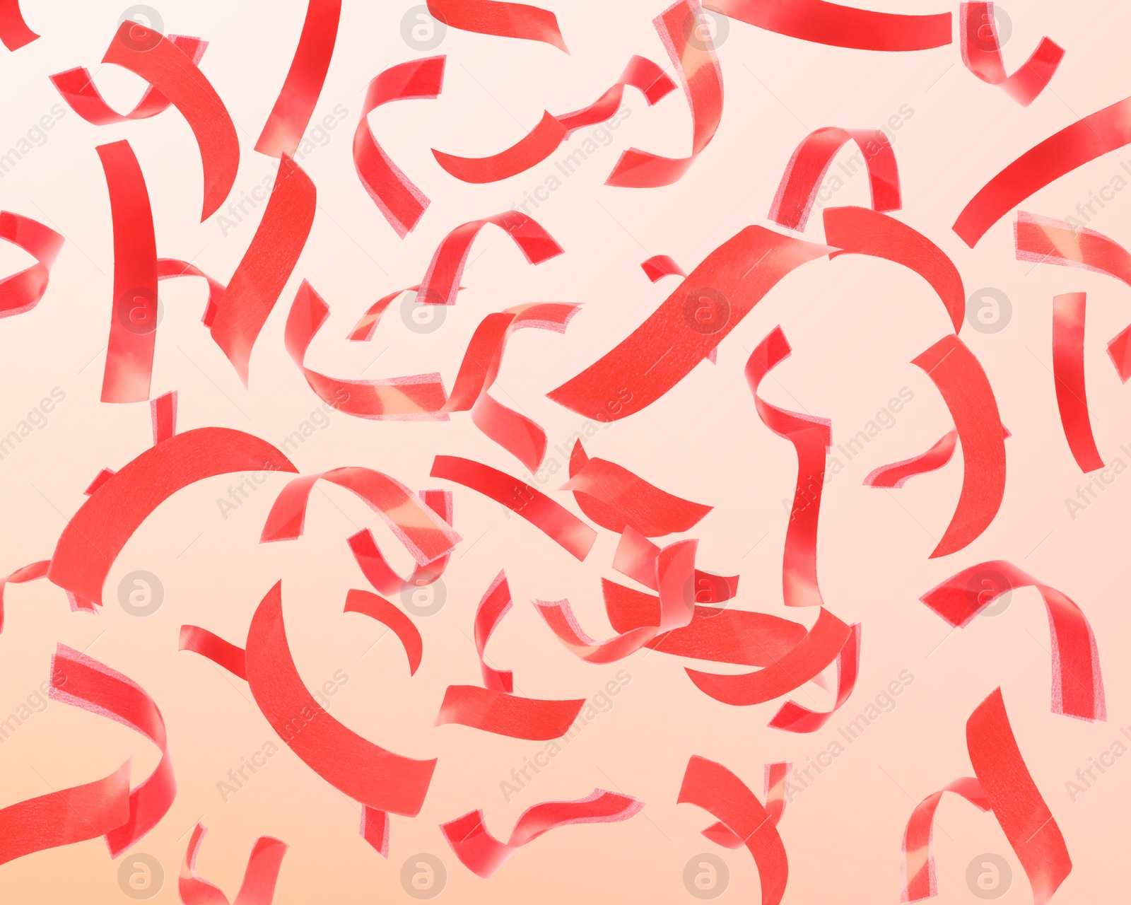 Image of Bright red confetti falling on gradient background