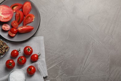 Delicious fresh tomatoes on grey table, flat lay. Space for text