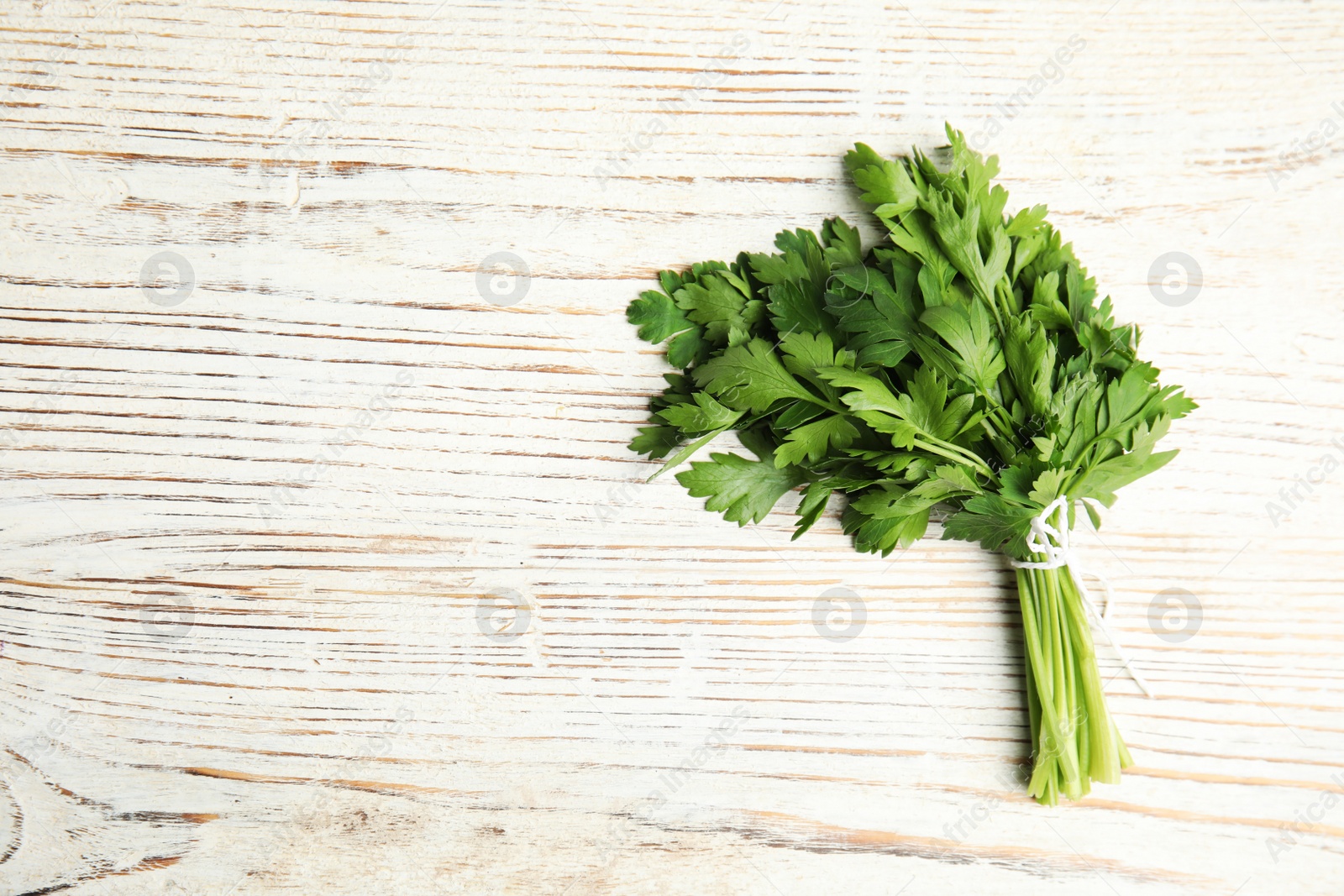 Photo of Bunch of fresh green parsley on wooden background, view from above. Space for text