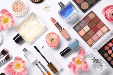 Flat lay composition with different makeup products and beautiful spring flowers on white background