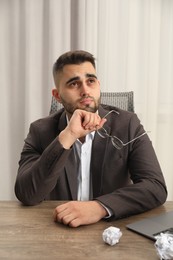 Photo of Sad businessman sitting at table in office