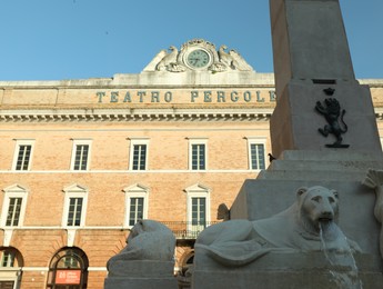 JESI, ITALY - MAY 17, 2022: Beautiful Obelisk and Teatro Comunale Pergolesi outdoors, low angle view