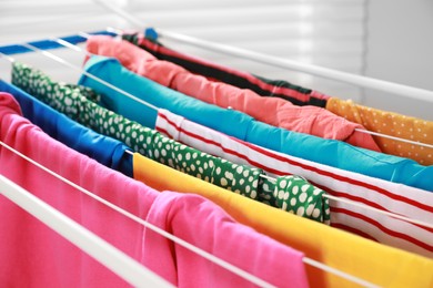 Clean laundry hanging on drying rack, closeup