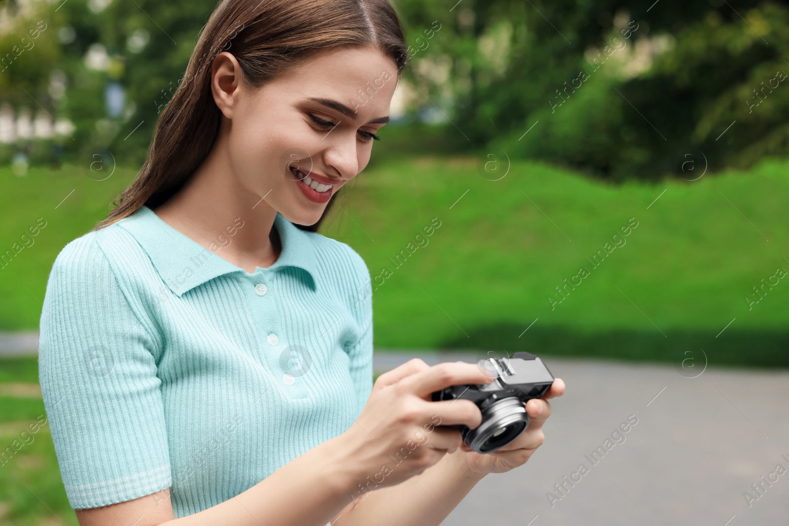 Photo of Young woman with camera in park, space for text. Interesting hobby