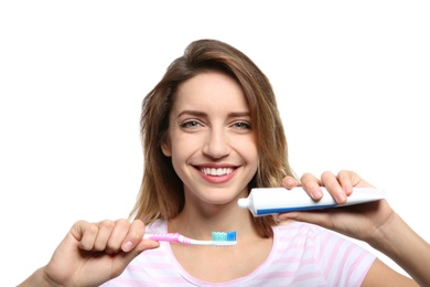 Photo of Portrait of young woman with toothbrush and paste on white background