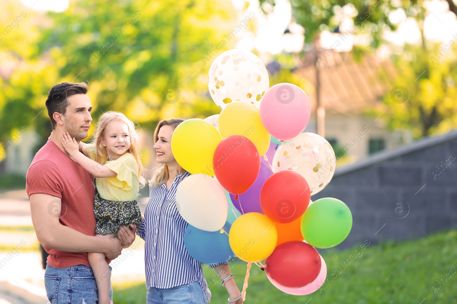 Photo of Happy family with colorful balloons in park on sunny day