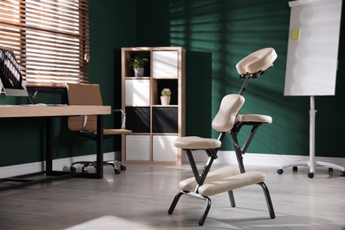 Photo of Modern massage chair in office, space for text. Medical equipment
