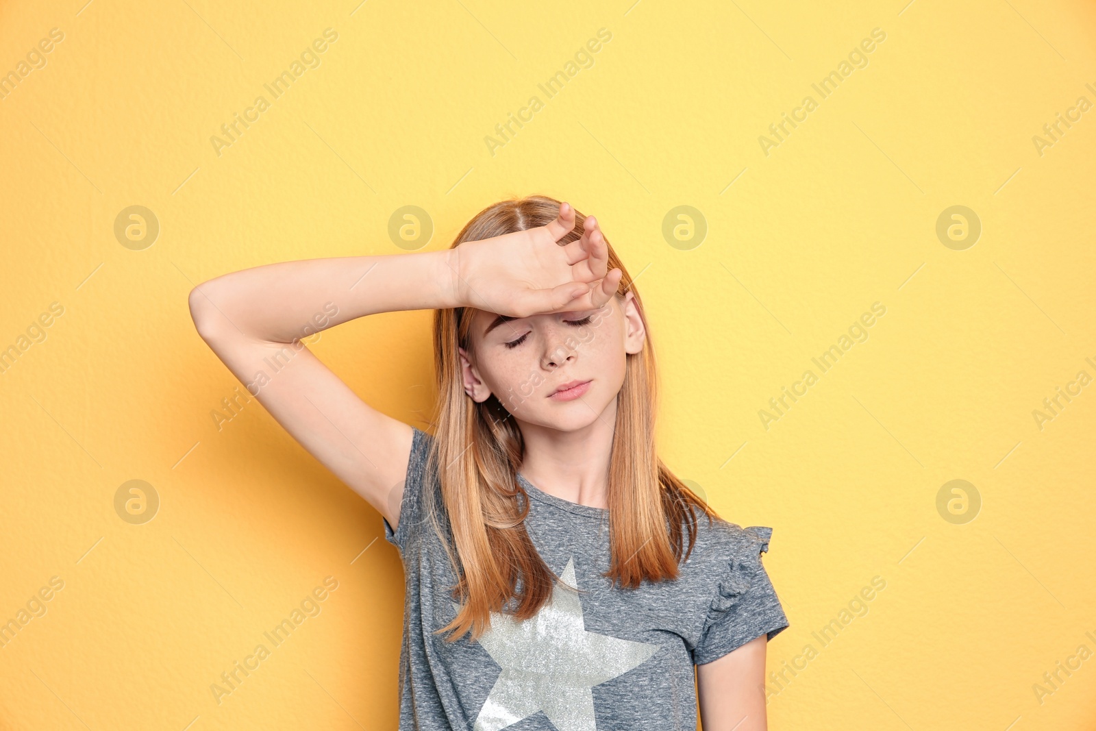 Photo of Teenage girl suffering from headache on color background