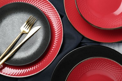 Stylish ceramic plates and cutlery on table, flat lay