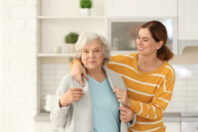 Photo of Elderly woman with female caregiver in kitchen