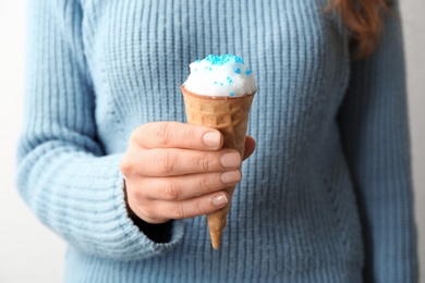 Photo of Woman with snow ice cream cone on light background, closeup