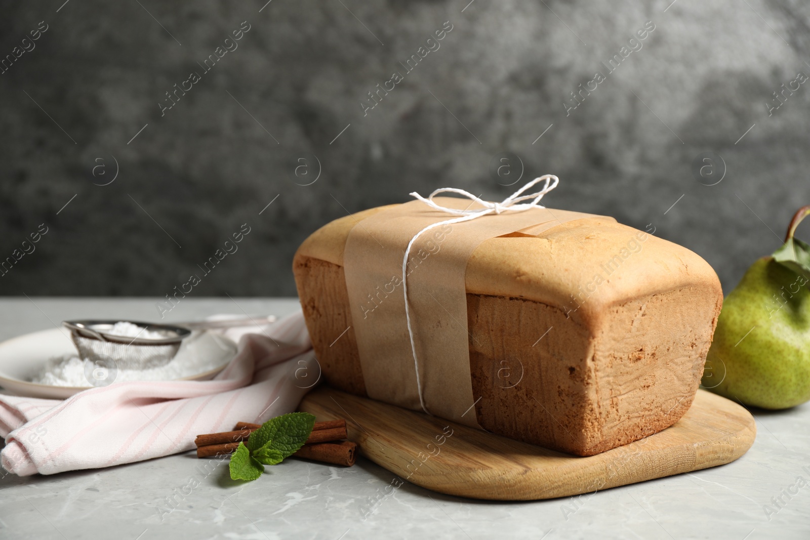 Photo of Tasty tied pear bread on light grey table. Homemade cake