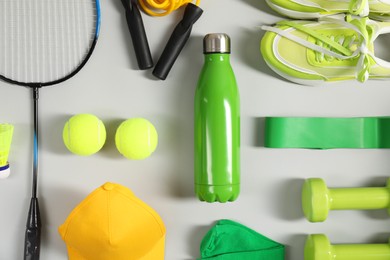 Different sports equipment on light grey background, flat lay