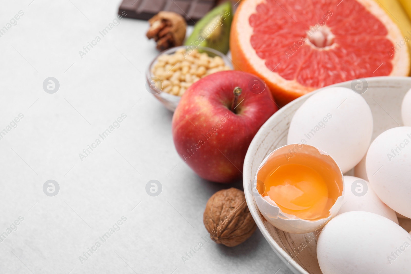 Photo of Natural sources of serotonin. Many different products on light table, closeup. Space for text