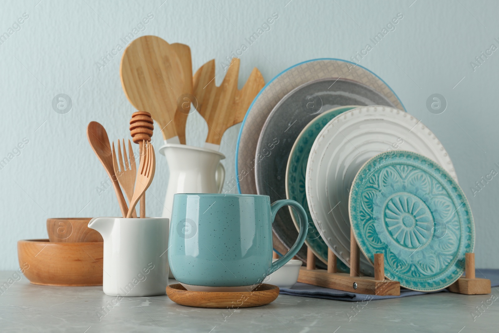 Photo of Set of kitchenware on grey marble table near light wall. Modern interior design