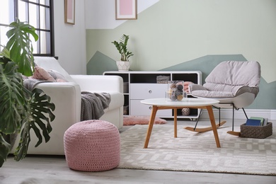 Photo of Stylish living room interior with comfortable sofa and rocking chair