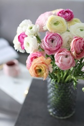 Photo of Bouquet of beautiful ranunculuses on table in living room