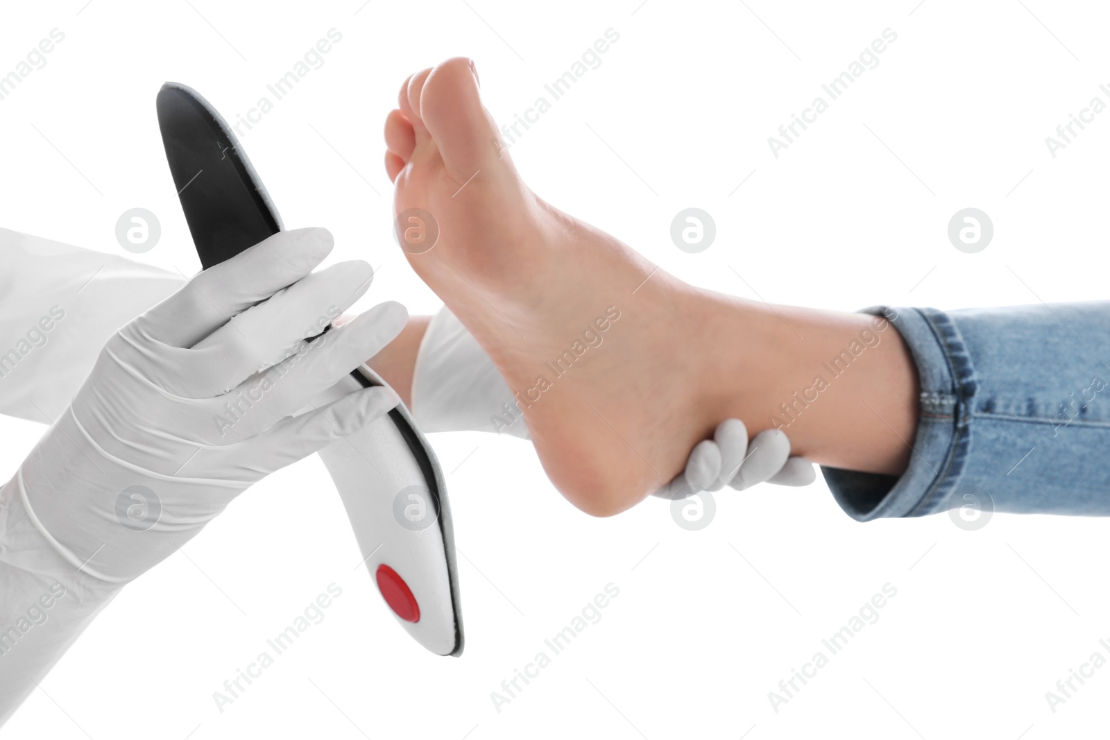 Photo of Orthopedist fitting insole on patient's foot against white background, closeup