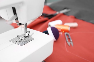 Photo of Sewing machine on table in tailor workshop, closeup