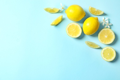 Photo of Frame made of lemons and flowers on color background, flat lay with space for text. Citrus fruits