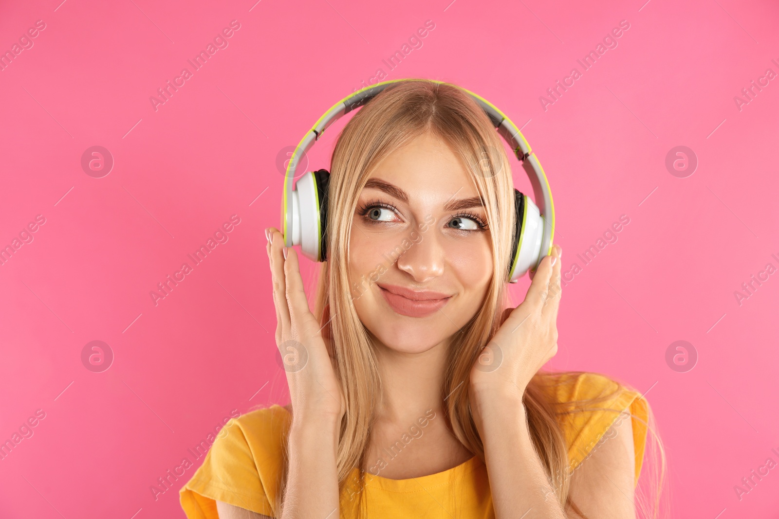 Photo of Beautiful young woman listening to music with headphones on color background