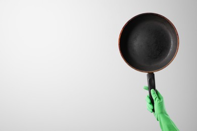 Woman holding empty frying pan on white background, closeup. Space for text