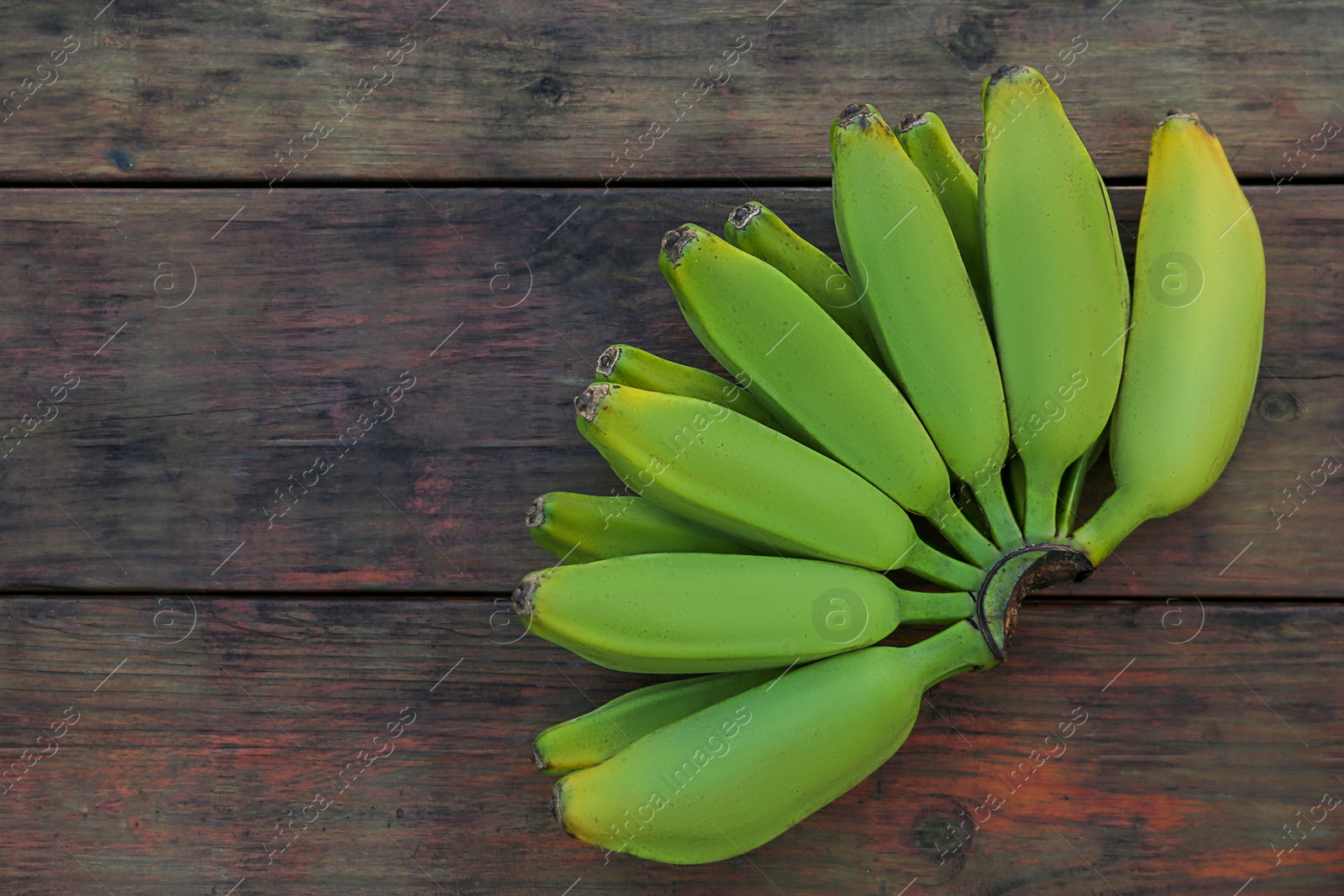 Photo of Bunch of delicious bananas on wooden table, top view. Space for text