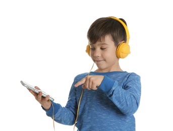 Cute little boy listening to music with headphones on white background