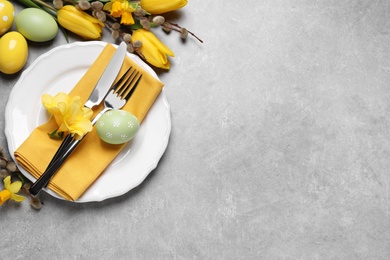 Photo of Festive Easter table setting with eggs on grey background, flat lay. Space for text