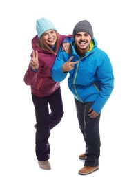 Photo of Young couple wearing warm clothes on white background. Ready for winter vacation