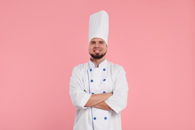 Happy professional confectioner in uniform on pink background