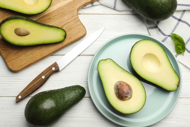 Photo of Delicious ripe avocados on white wooden table, flat lay