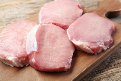 Pieces of raw pork meat on wooden table, closeup